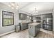 Updated kitchen with stainless steel appliances, granite counters, island, and modern gray cabinetry at 334 Stonehedge Dr, Carmel, IN 46032