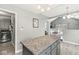 Kitchen island with granite countertop, gray cabinets, and stainless steel appliances at 334 Stonehedge Dr, Carmel, IN 46032