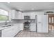 Bright kitchen featuring white cabinets, stainless steel appliances, and tiled flooring at 3462 Briar Creek Ln, Carmel, IN 46033