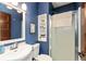 Updated bathroom with a blue accent wall, shower, and white vanity at 350 W Pearl St, Greenwood, IN 46142