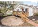 Charming backyard features a wooden deck with stairs, a brick patio and manicured landscaping at 356 S Washington St, Danville, IN 46122