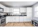 Bright kitchen with white cabinets, stainless steel appliances, and hardwood floors at 356 S Washington St, Danville, IN 46122