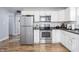 Well-lit kitchen featuring stainless steel appliances, white cabinets, and modern backsplash at 356 S Washington St, Danville, IN 46122
