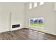 Open-concept living room with hardwood floors, modern fireplace, and expansive windows at 3727 Thomas Jefferson Ct, Westfield, IN 46074