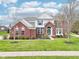 Charming two-story brick home featuring a well-maintained lawn, manicured shrubbery, and classic architectural details at 3932 Long Ridge Blvd, Carmel, IN 46074