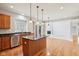 Bright kitchen with stainless steel appliances and island with view into adjacent room at 3932 Long Ridge Blvd, Carmel, IN 46074