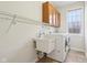 Bright laundry room features a utility sink, washer, dryer, window and storage cabinets at 3932 Long Ridge Blvd, Carmel, IN 46074