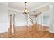 Elegant open-concept living area with hardwood floors, chandelier, and view of the staircase at 3932 Long Ridge Blvd, Carmel, IN 46074