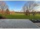 Beautiful backyard featuring an expansive lawn, mature trees, and a gravel patio at 3991 Clubhouse Dr, Greenfield, IN 46140