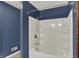 White bathtub with shower combination and blue wall accent in a renovated bathroom at 3991 Clubhouse Dr, Greenfield, IN 46140