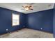 Cozy carpeted bedroom with natural light, ceiling fan, and navy blue walls at 3991 Clubhouse Dr, Greenfield, IN 46140