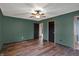 The bedroom is spacious with wood floors, green walls, a ceiling fan, and access to other rooms at 3991 Clubhouse Dr, Greenfield, IN 46140