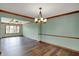 A well-lit dining room features wood floors, a modern chandelier, and neutral wall colors at 3991 Clubhouse Dr, Greenfield, IN 46140