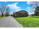Ranch home with a brick facade and a long driveway leading to the property, surrounded by green lawn at 3991 Clubhouse Dr, Greenfield, IN 46140