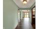 Hallway with wood floors and natural light flowing into the living room with a brick fireplace and wood beams at 3991 Clubhouse Dr, Greenfield, IN 46140
