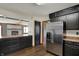 An open kitchen with dark cabinetry, stainless steel refrigerator, and a doorway to another room at 3991 Clubhouse Dr, Greenfield, IN 46140