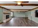 Spacious living room featuring wood floors, brick fireplace, beamed ceiling, and access to the outdoor area at 3991 Clubhouse Dr, Greenfield, IN 46140