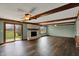 Bright living room with wood floors, brick fireplace, wood beams and sliding glass doors to the backyard at 3991 Clubhouse Dr, Greenfield, IN 46140