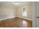 Standard empty bedroom with hardwood floors, neutral walls, white trim, and one bright window at 40 N Ritter Ave, Indianapolis, IN 46219
