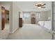 Bright bedroom with neutral walls, carpet, ceiling fan, and dressers; bathroom shower visible through doorway at 40 N Ritter Ave, Indianapolis, IN 46219