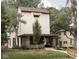 Charming two-story home with a brick-accented porch, awning-covered windows, and mature trees at 40 N Ritter Ave, Indianapolis, IN 46219