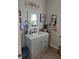 Bathroom with gray vanity, modern light fixture, framed mirror, and gray walls at 422 Hege Ave, Columbus, IN 47201