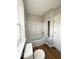 Bathroom featuring a white bathtub with shower, a toilet, a small window, and vinyl flooring at 422 Hege Ave, Columbus, IN 47201