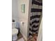 Bathroom featuring a toilet with blue-striped shower curtain and coastal decorations at 422 Hege Ave, Columbus, IN 47201