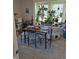 Carpeted dining room with a wooden table, upholstered chairs, and large window filled with hanging plants at 422 Hege Ave, Columbus, IN 47201