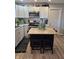 Well-lit kitchen features white cabinets, stainless steel appliances, and a stylish black island with light wood countertop at 422 Hege Ave, Columbus, IN 47201