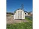 A shed with tan siding and white trim sits on a concrete slab in the backyard at 422 Hege Ave, Columbus, IN 47201