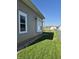 View of the side yard with green grass and gravel adjacent to the house and shed in background at 422 Hege Ave, Columbus, IN 47201