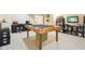 Basement game area with a custom-made table, TV, office desk, and shelving for games and storage at 4281 Honeysuckle Ln, Zionsville, IN 46077