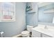 Powder room featuring a white vanity, toilet, and decor shelving beneath a sunlit window at 4281 Honeysuckle Ln, Zionsville, IN 46077
