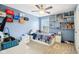 Bedroom with blue walls, ceiling fan, built-in shelves, carpet flooring, and a window at 4281 Honeysuckle Ln, Zionsville, IN 46077