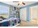 Bedroom with blue walls, ceiling fan, built-in shelves, carpet flooring, and a window at 4281 Honeysuckle Ln, Zionsville, IN 46077