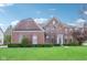 Charming two-story brick home with manicured lawn and lush landscaping under a bright blue sky at 4281 Honeysuckle Ln, Zionsville, IN 46077