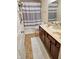 Cozy bathroom featuring a double sink vanity with dark wood cabinets and a neutral-striped shower curtain at 4383 Round Lake Bnd, Indianapolis, IN 46234