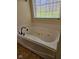 A relaxing tub with jets is nestled by a window with natural sunlight at 4383 Round Lake Bnd, Indianapolis, IN 46234