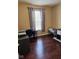 Cozy bedroom with dark wood floors, a window, desk, and neutral paint at 4383 Round Lake Bnd, Indianapolis, IN 46234