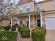Inviting two-story home featuring a charming front porch, lush landscaping, and a well-maintained lawn at 4383 Round Lake Bnd, Indianapolis, IN 46234