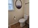 A toilet is situated next to a window and decorative art at 4383 Round Lake Bnd, Indianapolis, IN 46234