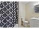 Bathroom with a black and white shower curtain, toilet, and vanity with storage at 443 N Alton Ave, Indianapolis, IN 46222