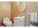 Updated bathroom with a modern toilet, sink vanity, round mirror, and decorative towel at 443 N Alton Ave, Indianapolis, IN 46222