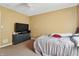 Neutral-colored bedroom with a large TV, ceiling fan, and a comfortable queen-sized bed at 443 N Alton Ave, Indianapolis, IN 46222