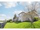 A brick house with a wooden deck on a lush lawn is next to a fenced-in lake at 476 Sapphire Dr, Carmel, IN 46032