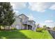 The backyard of a brick house features a wooden deck and stairs to a lush lawn at 476 Sapphire Dr, Carmel, IN 46032