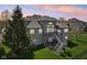 Gray brick home featuring a large deck, stairs leading to the lawn, lush landscaping, and mature trees at 476 Sapphire Dr, Carmel, IN 46032