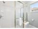 Bathroom shower featuring glass doors, white tile, and chrome fixtures at 476 Sapphire Dr, Carmel, IN 46032