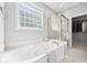 Bathroom featuring a soaking tub, glass block window, and walk-in shower at 476 Sapphire Dr, Carmel, IN 46032